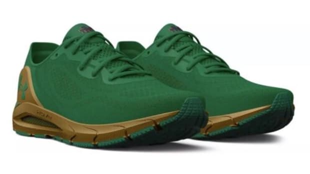 View of green, navy, and gold Under Armour shoes.